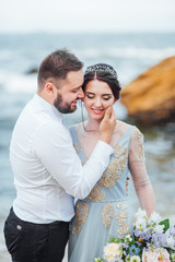 same couple with a bride in a blue dress walk