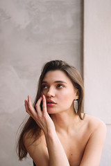 Single young attractive thinking woman with fingers on face