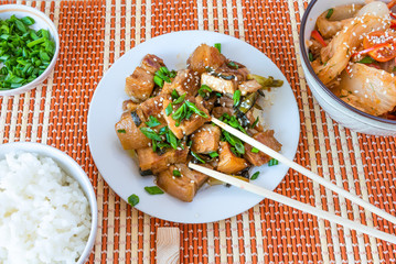 Traditional Asian lunch - spicy pork, rice, salad with Chinese cabbage, peppers and tomatoes. Korean dinner with pork belly, rice, kimchi salad