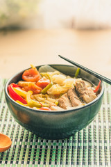 Suan cai - Traditional Chinese soup of pork and pickled Chinese cabbage in a black bowl.