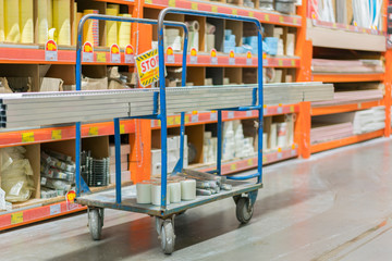 construction cart in the building store. Carts loaded with boards. shop of building materials. Racks with boards, wood and building material. loaded cart in a hardware store