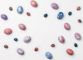 Creative Frame background with quail, pink, purple and blue easter eggs with copy space for text. isolated on white background. Flat lay, top view.