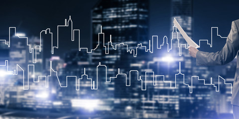 Man architect or engineer presenting construction concept and holding documents in hand