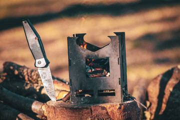Firebox and knife. Tourist camp.
