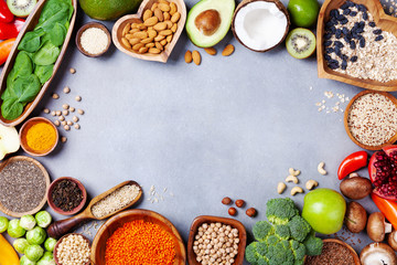 Healthy food background from fruits, vegetables, cereal, nuts and superfood. Dietary and balanced vegetarian eating products on kitchen table top view.