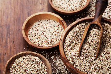 Mixed quinoa in bowl on wooden kitchen table. Healthy and diet superfood product.