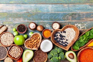 Healthy food background from fruits, vegetables, cereal, nuts and superfood. Dietary and balanced vegetarian eating products on kitchen table top view.