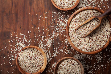 Mixed quinoa in bowl on wooden kitchen table top view. Healthy and diet superfood product.