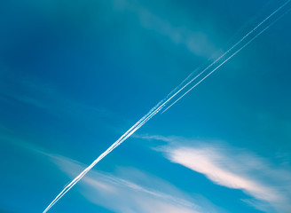 Airplane with contrail in the blue sky