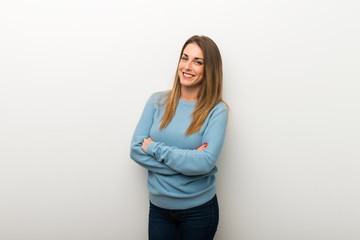 Blonde woman on isolated white background keeping the arms crossed in frontal position