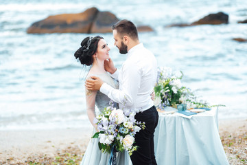 same couple with a bride in a blue dress walk