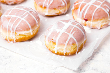 Traditional Polish donuts with white frosting on white background. Tasty doughnuts with jam.