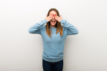 Blonde woman on isolated white background covering eyes by hands. Surprised to see what is ahead