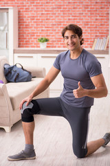Young handsome man doing sport exercises at home 