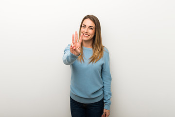 Blonde woman on isolated white background happy and counting three with fingers