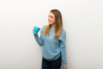 Blonde woman on isolated white background holding a hot cup of coffee