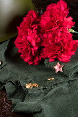 bouquet of red flowers on a military background with a star close-up