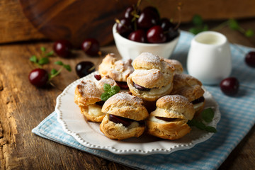 Choux pastry buns with custard and cherry