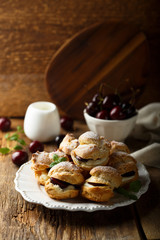 Obraz na płótnie Canvas Choux pastry buns with custard and cherry
