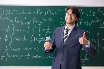 Young male math teacher in classroom 