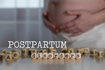 Words POSTPARTUM DISORDERS composed of wooden letters.