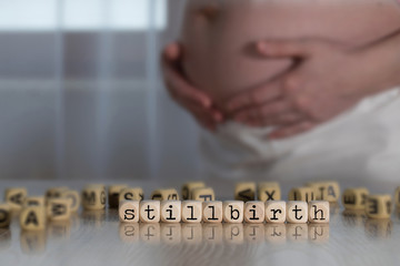 Word STILLBIRTH composed of wooden letters.