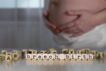 Words BREECH BIRTH composed of wooden letters.