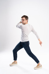 Full-length photo of funny man 30s in casual t-shirt and jeans jumping isolated over white background.