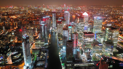 Aerial drone night shot from iconic Canary Wharf skyscrapers business area, Isle of Dogs, London,...