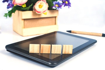 Wood block sign on mobile tablet for Online shopping and ecommerce.