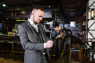 Fashionable videographer shoots the clip in a luxury restaurant. Shooting a video clip in a pub