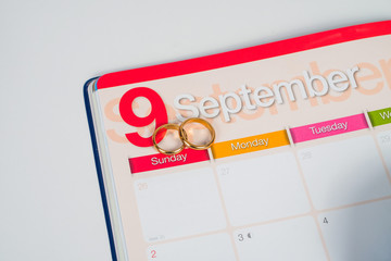 Gold Wedding ring on calendar planning or office tool.