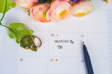 Word Wedding to Reminder Wedding day with Wedding ring on calendar planning and office tool.