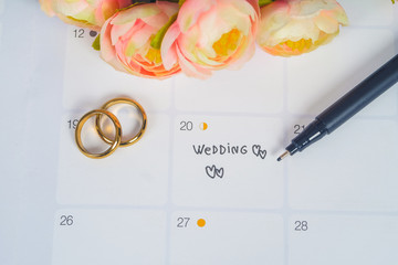 Word Wedding to Reminder Wedding day with Wedding ring on calendar planning and office tool.