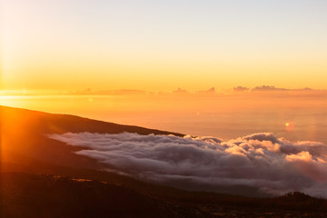 Incredible sunset landscape in the mountains. Clouds lie on the mountainside