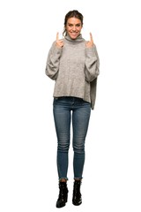 A full-length shot of a Blonde woman with turtleneck pointing with the index finger a great idea over isolated white background