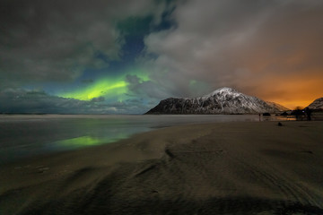 Photographers with tripods during aurora borealis hunting at Skagsanden beach. Lofoten Islands, Norway, Scandinavia