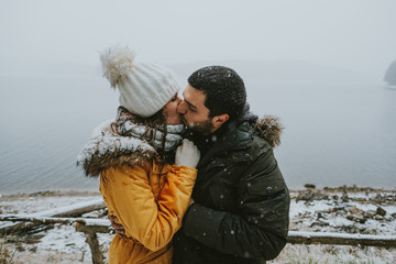 Young couple kissing in winter forest