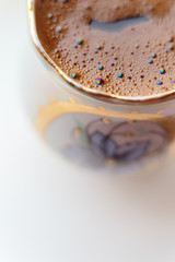 ISOLATED: Macro shot of brewed coffee in a round cup - Rainbow sparkles with bubbles
