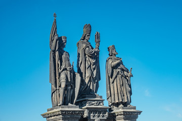Fototapeta na wymiar Statue of knights and priest at the Charles Bridge in Prague, Czech Republic, summer time, blue sky