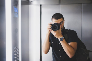 young man with a camera in the mirror