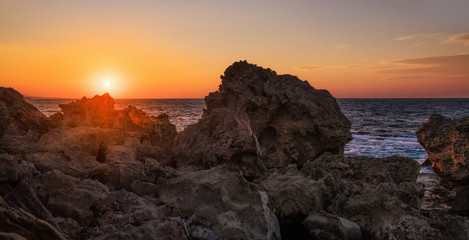 Seascape sunset with rock formation on the foreground