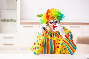 Male clown preparing for perfomance at home 