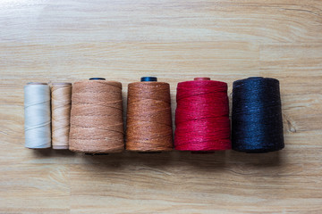Colorful wax thread on brown wood background