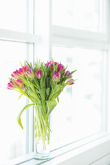  Bouquet of spring tulips in a vase on the window