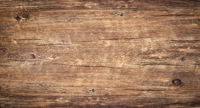 Wood texture background. Rough surface of old knotted table with nature pattern. Top view of vintage wooden timber with cracks. Brown rustic wood for backdrop.