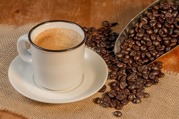 taza de café con granos esparcidos sobre madera