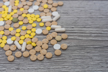 Medical colorful pills, capsules or supplements for the treatment and health care on wooden background.