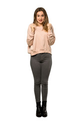 A full-length shot of a Teenager girl with pink sweater celebrating a victory in winner position over isolated white background