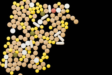 Assorted pharmaceutical medicine pills, tablets and capsules on black background. Creative idea. Drugs. Sad. Die. Illness.